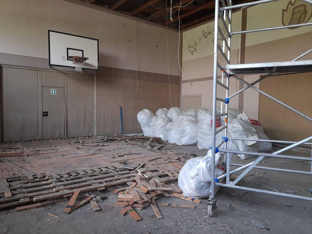 Entkernte Turnhalle mit Blick auf Basketballkorb