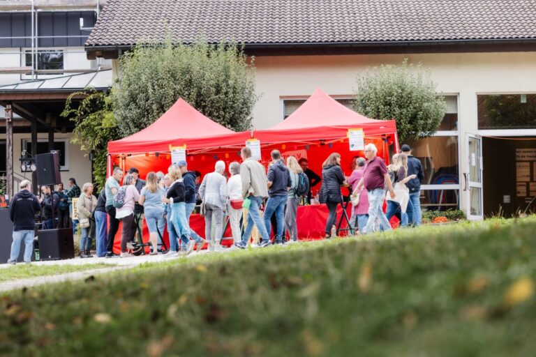 Menschenmeneg vor zwei Pavillons