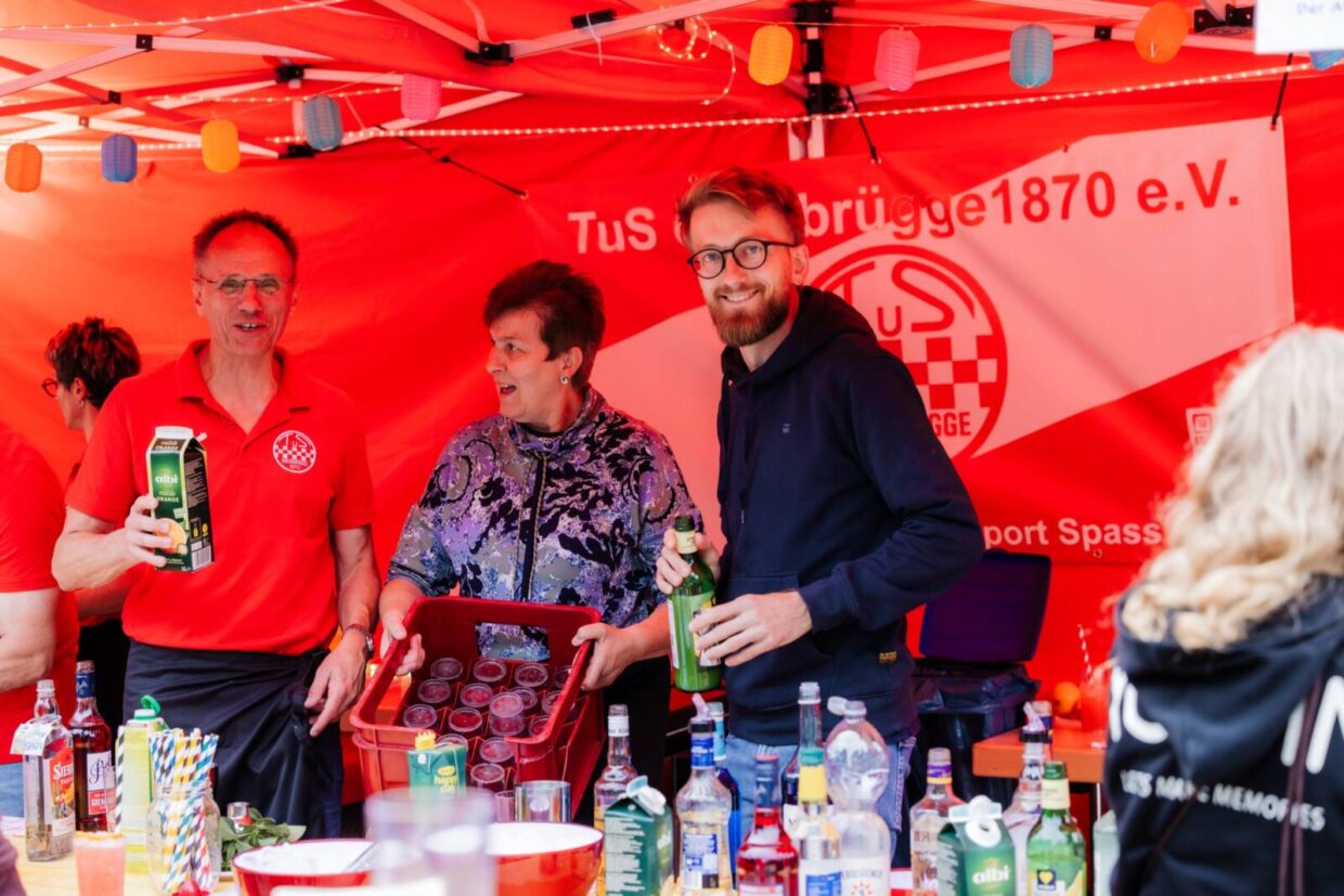 Drei fröhliche Menschen am Cocktailstand
